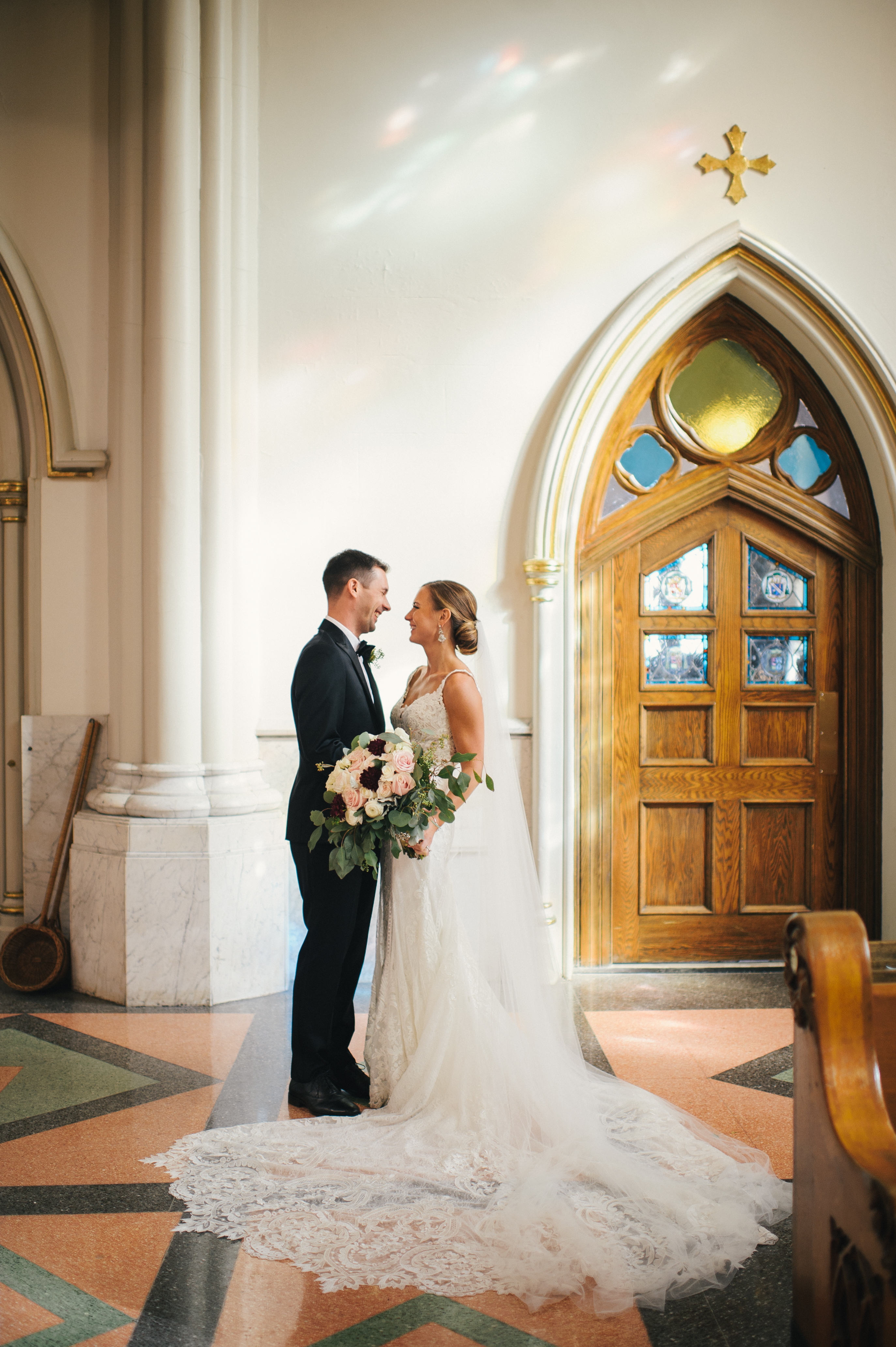 bride and groom in a church filled with beautiful sunlight